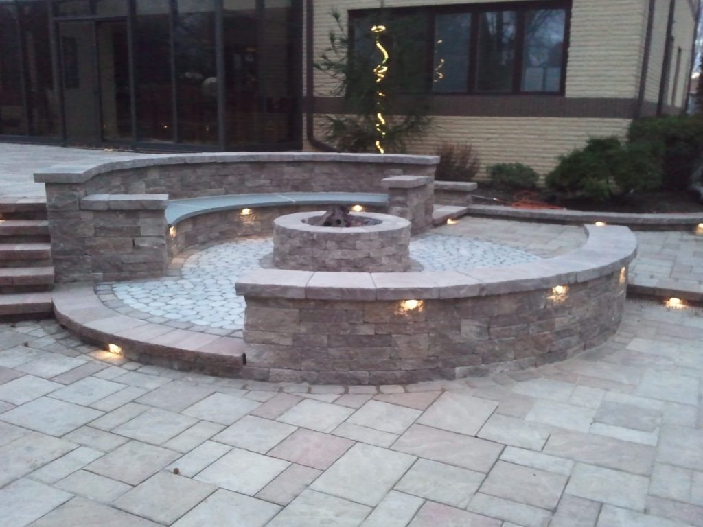 Firepit with decorative walls that form benches around the pit.