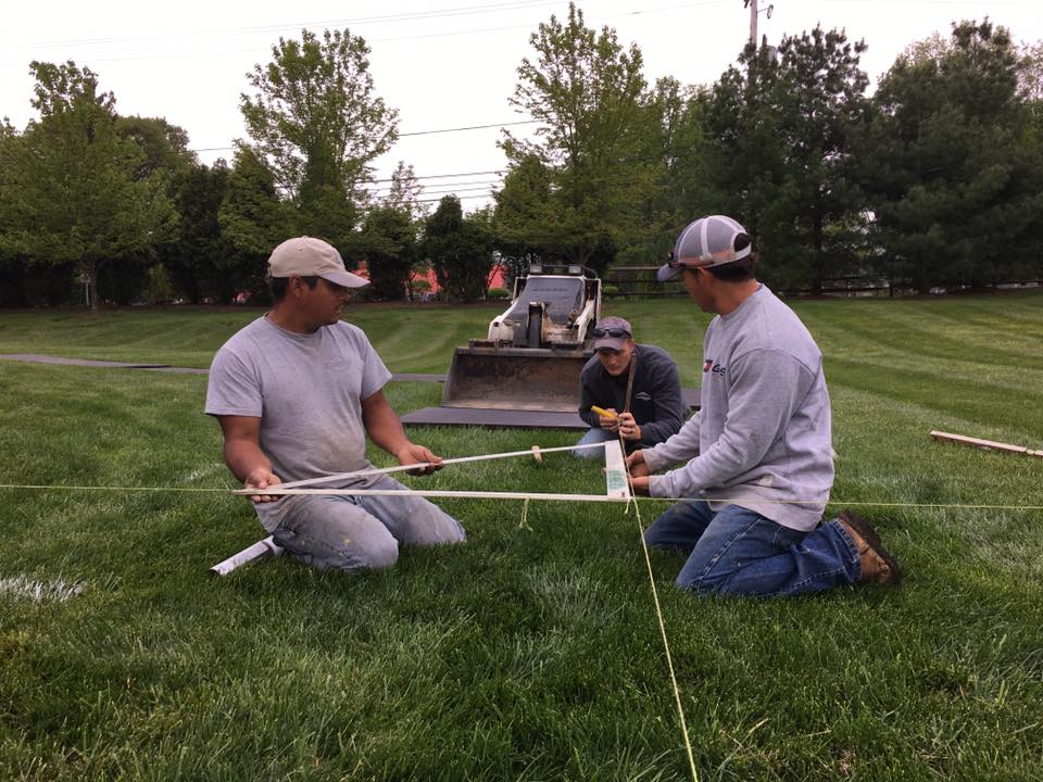 Stoneworx team measuring in the grass