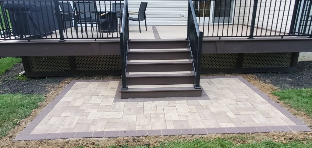 brown deck of composite material with steps leading down to a patio
