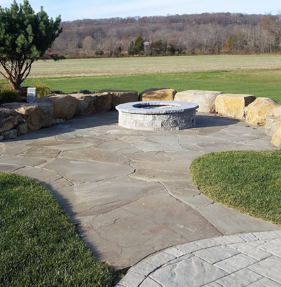 Fire pit in an open field with natural stone walls