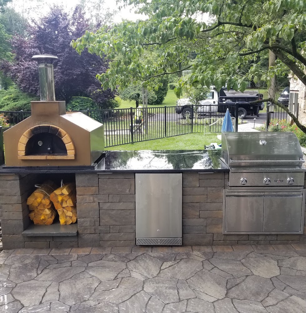Outdoor kitchen area with grill and wood fire stove
