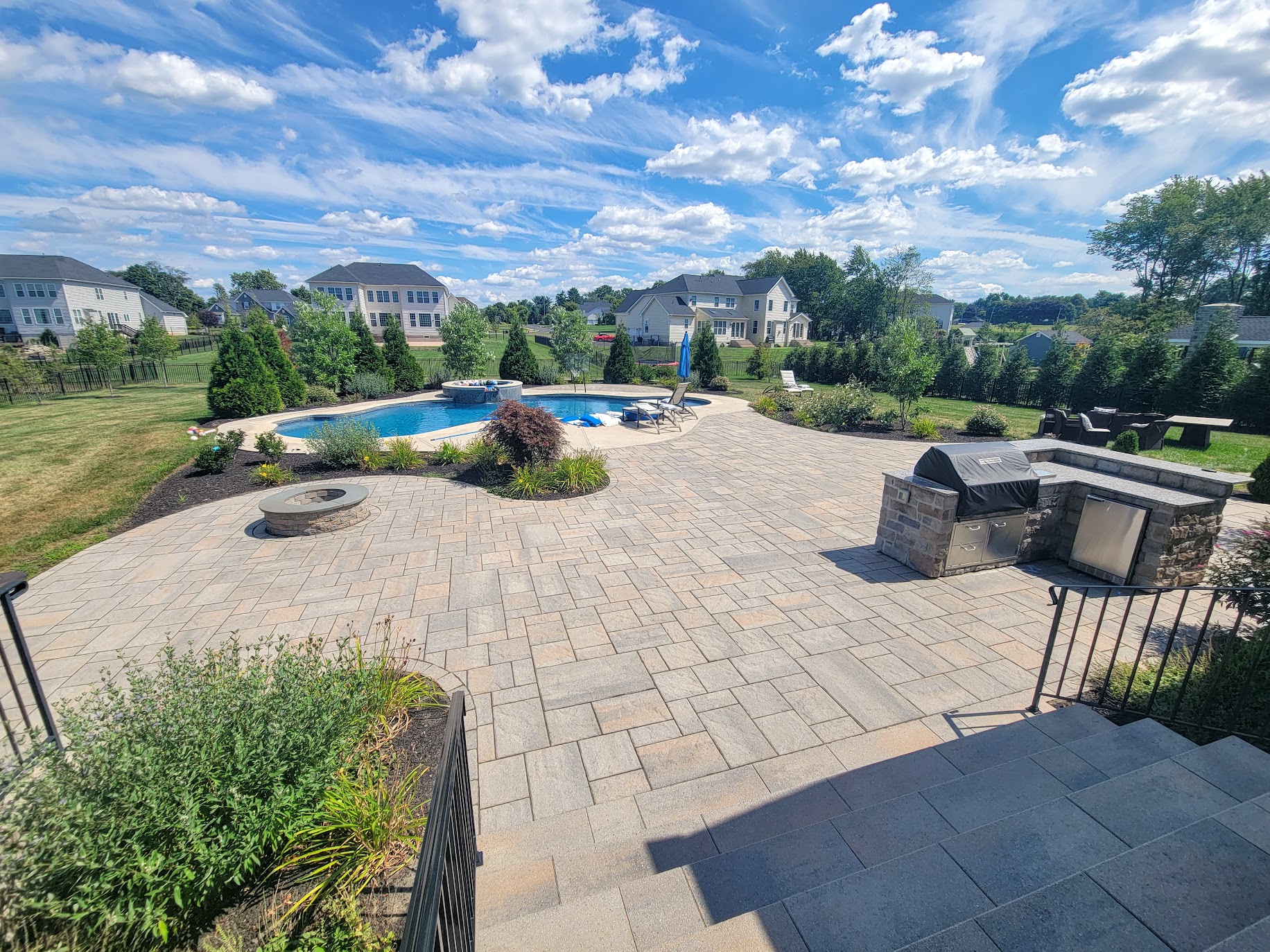 large patio area with fire pit, grill area, and pool
