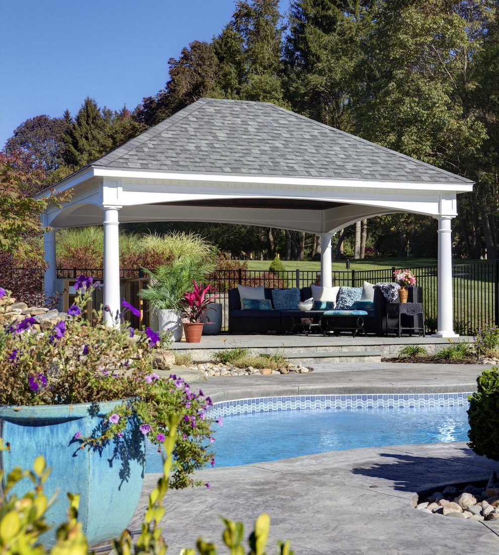 Custom vinyl cabana on raised stone dais next to a pool