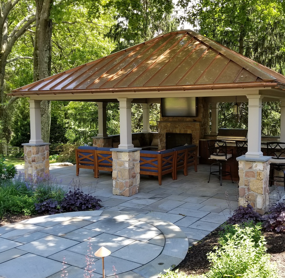 custom patio with a copper roofed pavilion, outdoor furniture, and television